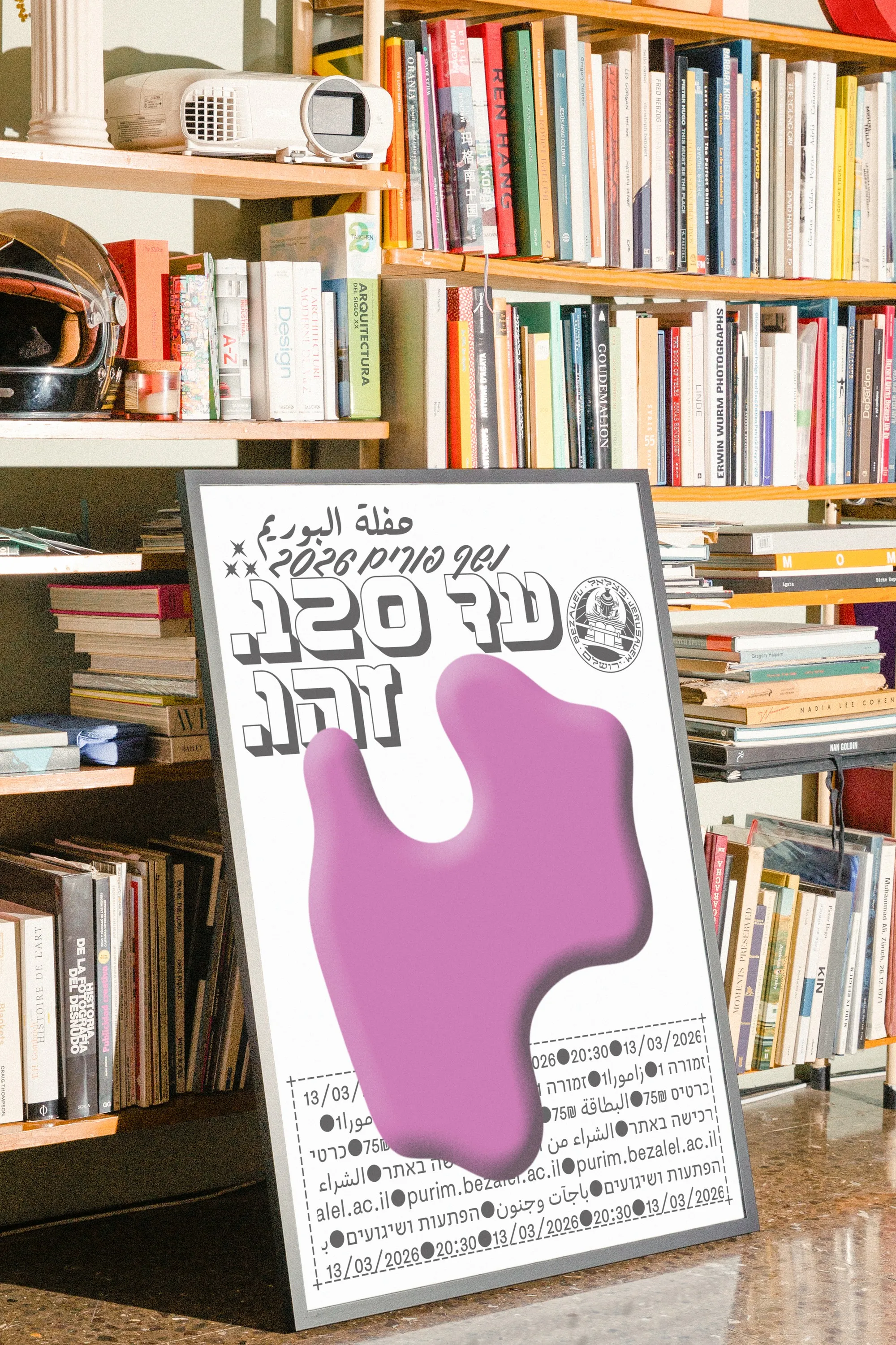 The Purim ball poster framed against a bookshelf