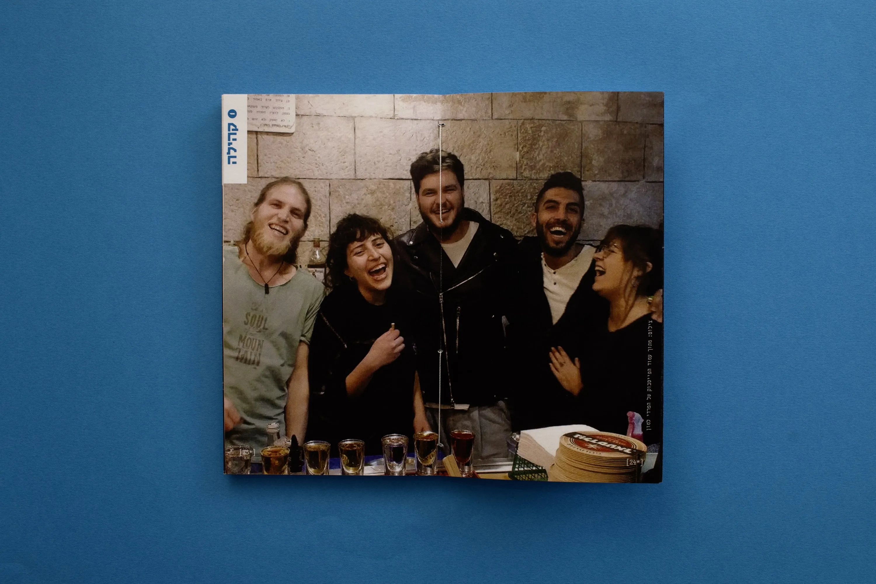 A full-bleed photograph of the bar staff laughing together behind the counter